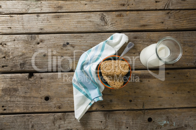 Granola bar and milk with napkin on wooden table