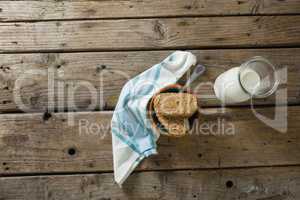 Granola bar and milk with napkin on wooden table