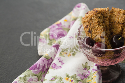 Granola bar and berry fruits on black background