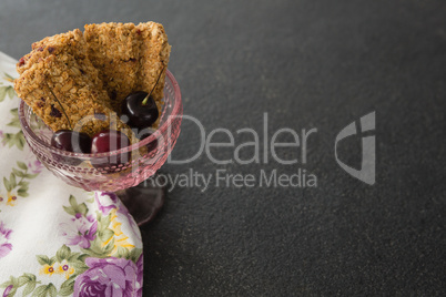 Granola bar and berry fruits on black background