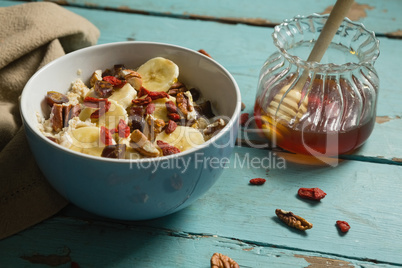 Fruit cereal and honey on a wooden table