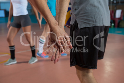 Cropped image of volleyball player holding hand with teammate