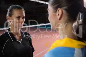 Female volleyball players looking each other