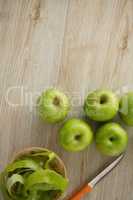 Overhead view of granny smith apples by peel and knife