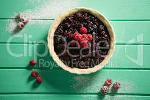 Directly above shot of raspberries and blackberries on tart in baking pan