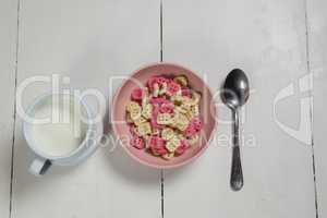 Bowl of honeycomb cereal and milk on wooden table