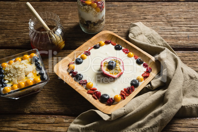 Various fruit cereals and honey on a wooden table