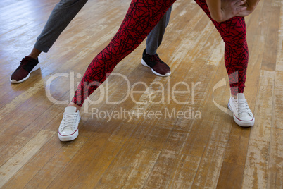 Low section of friends rehearsing dance on wooden floor