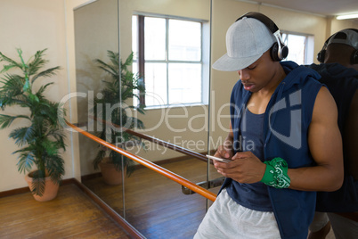 Male dancer using phone in studio