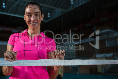 Portrait of female volleyball player behind net