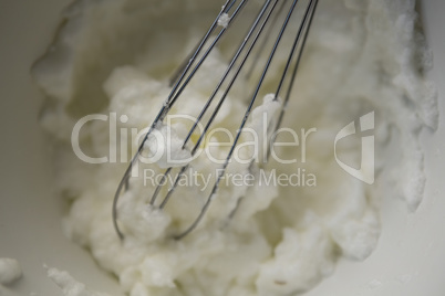 Close up of wire whisk and whipped cream