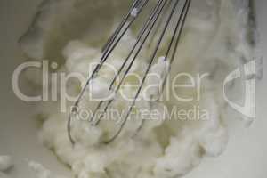 Close up of wire whisk and whipped cream