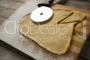 High angle view of dough with pastry cutter