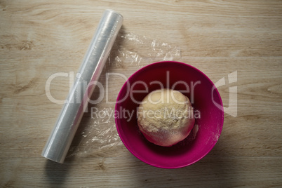 Overhead view of kneaded dough in pink bowl