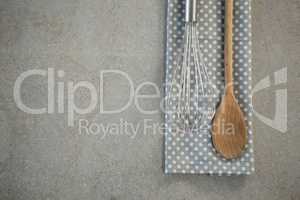Overhead view of wire whisk on napkin