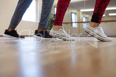 Low section of woman with friend rehearsing dance on floor