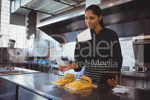 Waitress with tablet and food in cafe