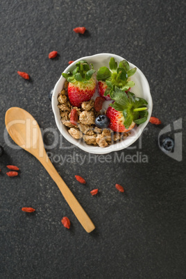 Bowl of breakfast cereals and fruits with spatula