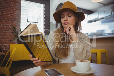 Woman reading book in cafe