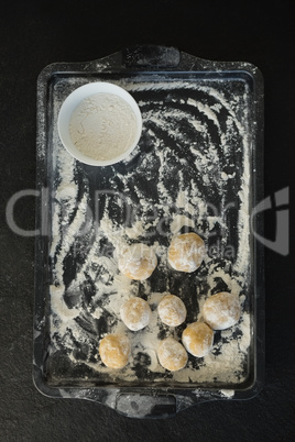Overhead view of dough with flour on baking sheet