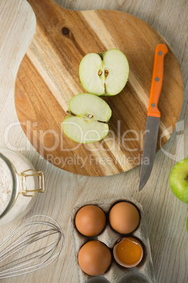 Overhead view of granny smith apple halved on cutting board