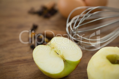 Close up of wire whisk by eggs granny smith apple