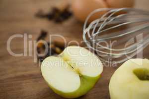 Close up of wire whisk by eggs granny smith apple