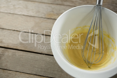 High angle view batter and wire whisk in bowl
