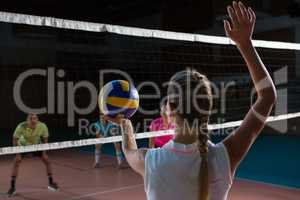 Rear view of volleyball player playing with teammates