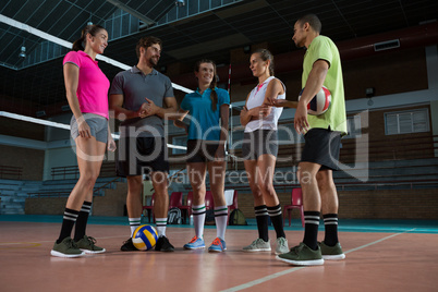 Full length of volleyball players discussing
