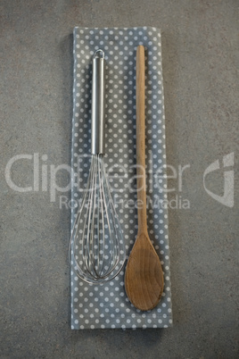 Overhead view of wire whisk on napkin