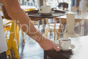 Cropped hand of waiter serving coffee