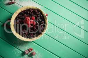 High angle view of raspberries and blackberries on tart in baking pan