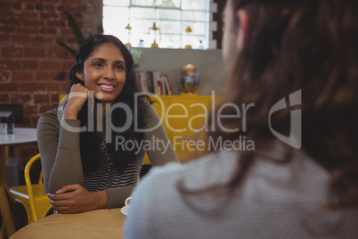 Woman looking at friend in cafe