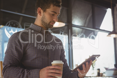 Businessman using tablet while having coffee