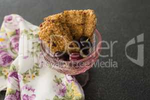 Granola bar and berry fruits on black background