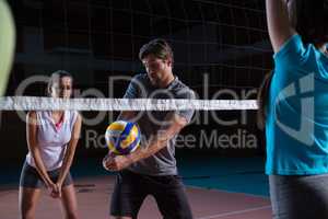Player with teammates practicing volleyball