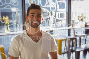 Portrait of happy waiter in cafe