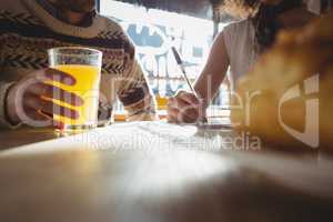 Midsection of man with woman having juice in cafe