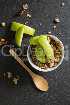 Bowl of breakfast cereals with fruits on black background