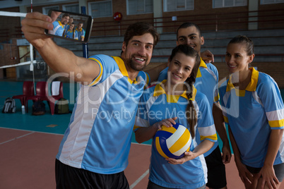 Male volleyball player with team taking selfie