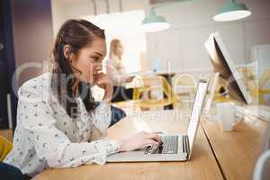 Female executive working on laptop in office