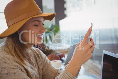 Woman using phone in cafe