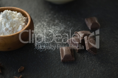 Close up of chocolate bars by flour in bowl