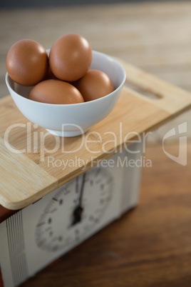 Brown eggs in bowl on weight scale