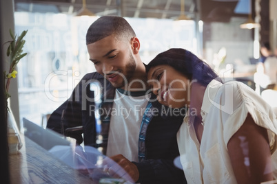Young woman leaning on man shoulder in cafe