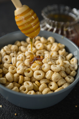 Honey being poured in bowl of cereal rings