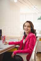 Portrait of happy female executive working at desk