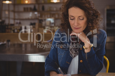Businesswoman writing in cafe