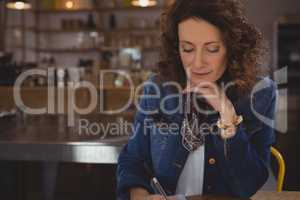 Businesswoman writing in cafe